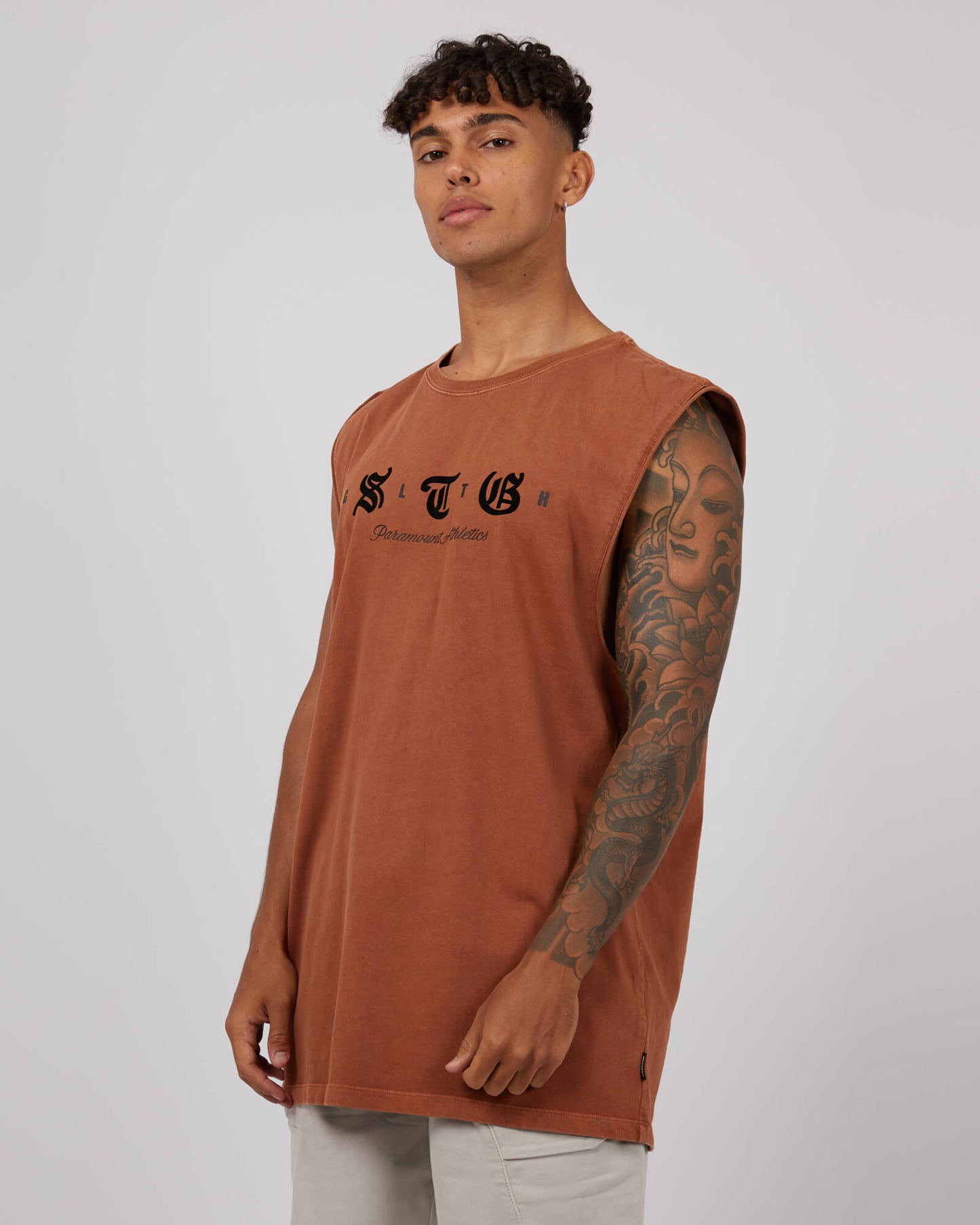 Stewarts Menswear St Goliath Silhouette Muscle Tee. Colour is Mocha. Black flocked branding on front. Photo shows model wearing St Goliath Silhouette Muscle Tee, front view.