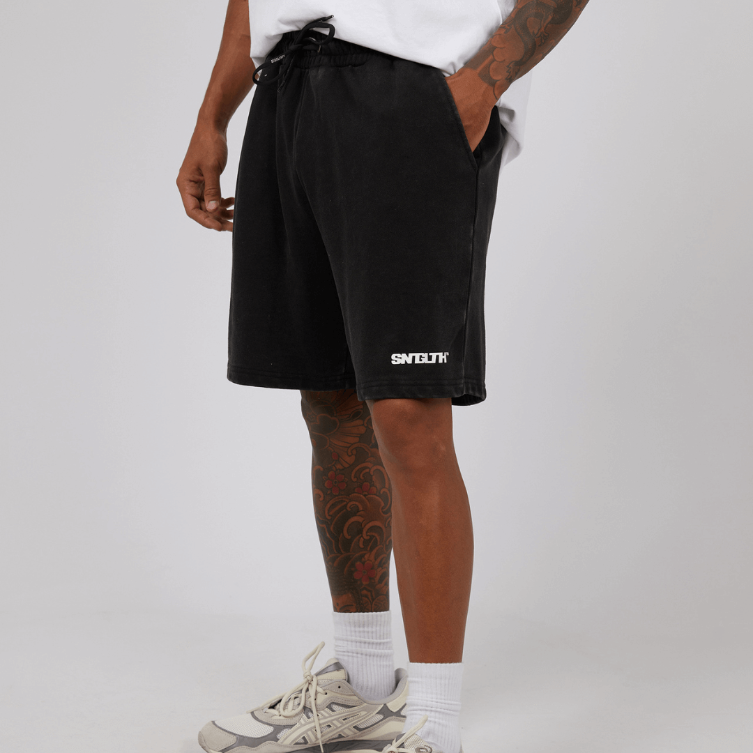 Stewarts Menswear St Goliath Track Fleece Shorts. These soft, breathable elastic waist fleece shorts have two back pockets and a subtle logo. Photo shows close up of model wearing St Goliath Fleece Track Shorts. Colour is Washed Black.