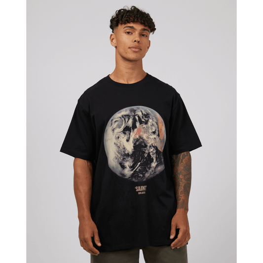 Stewarts Menswear St Goliath World Tee. Colour is black with large "world" print on front. Photo shows model wearing St Goliath World T-shirt, front view.