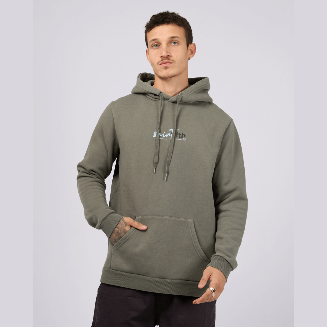 Stewarts Menswear mullumbimby. St Goliath Sign Off Hoodie. Colour is light army green. Photo shows front view of model wearing St Goliath Sign Off Hoodie with Saint Goliath branded print in mint blue and charcoal colour.