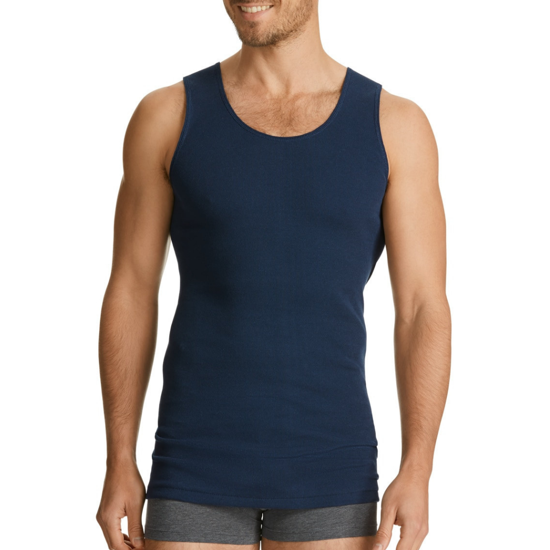 A man wearing a navy blue Chesty Bond Men's Singlet by Bonds, standing with hands at his sides. Bonds Chesty Bond Singlet available at Stewart’s Menswear Mullumbimby in ribbed cotton with classic men’s styling.