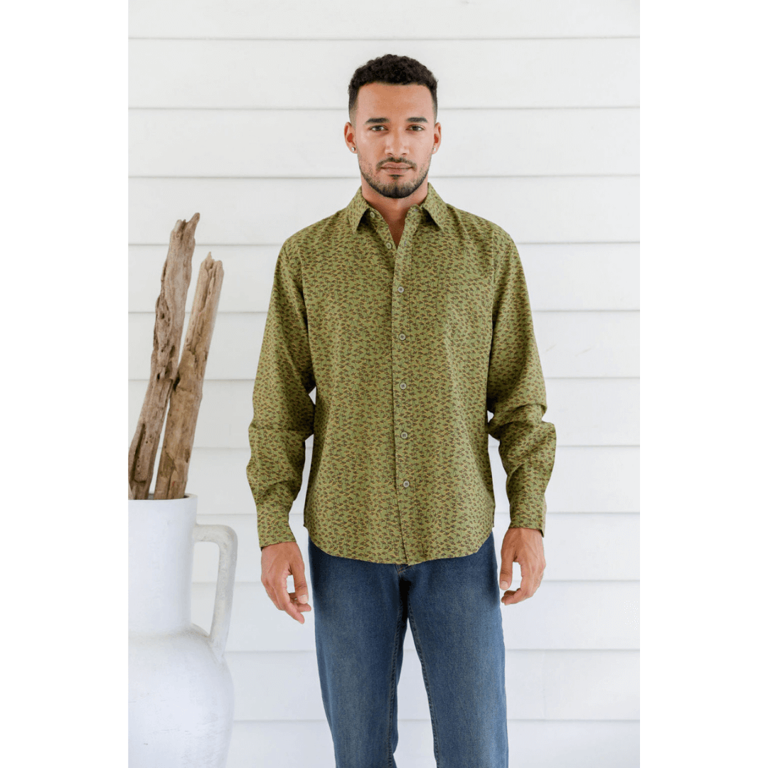 Male model is wearing a Hemp/cotton blend men's long sleeve shirt. Green with brown and mustard dandelion seeds printed all over. Front view.