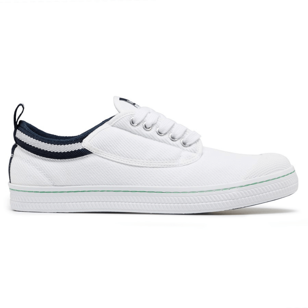 Stewart's Menswear Dunlop Volley Classic shoe. Whether you're dressing up or down, Dunlop Volleys are versatile and will add retro style to your outfit.  The simple design features a canvas upper with a moulded rubber toe cap and a contrasting stripe on the side.  The shoe's original herringbone rubber outsole is slip resistant and non-marking. White side view.