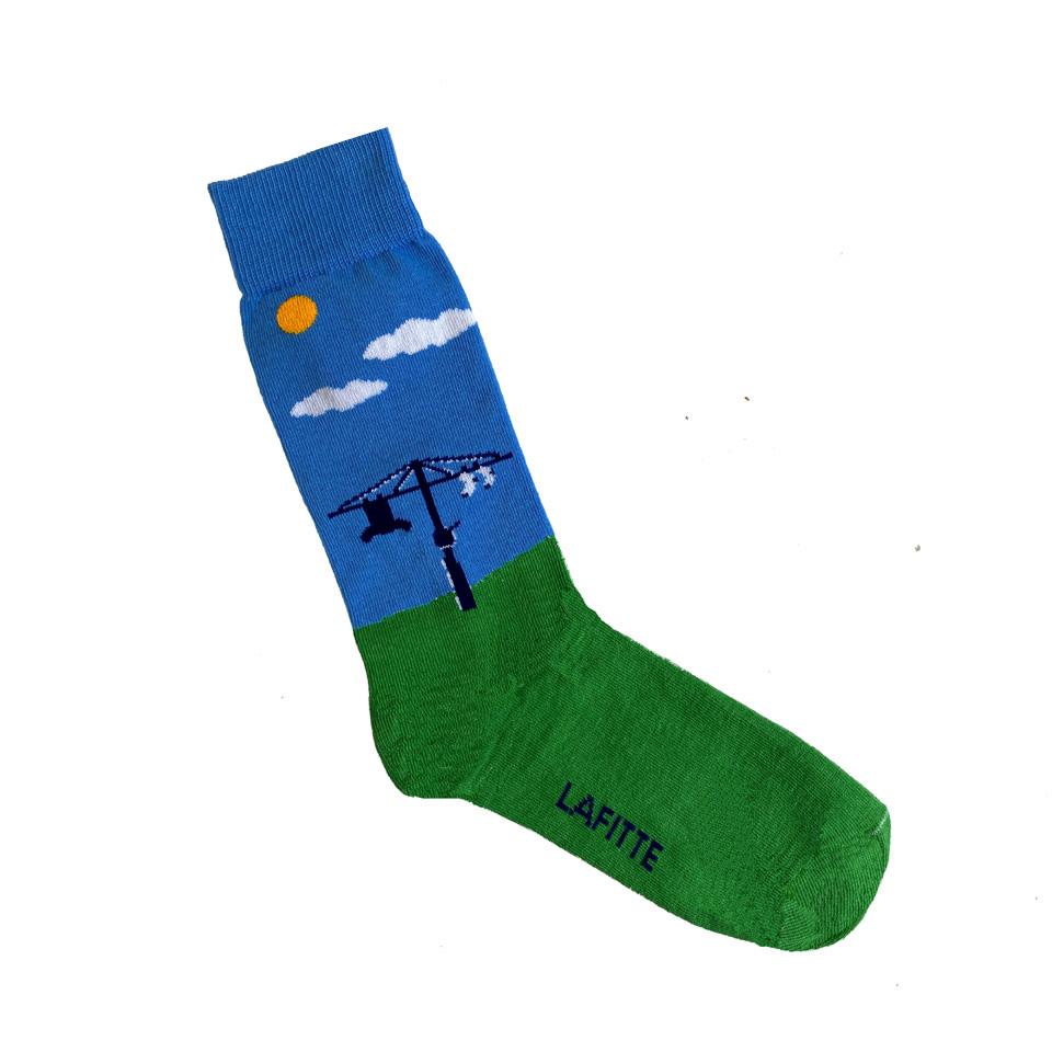 Australian Made novelty socks. Sock has green foot (representing grass) and a blue leg (representing sky) with a Hills Hoist, Sun plus a few clouds.