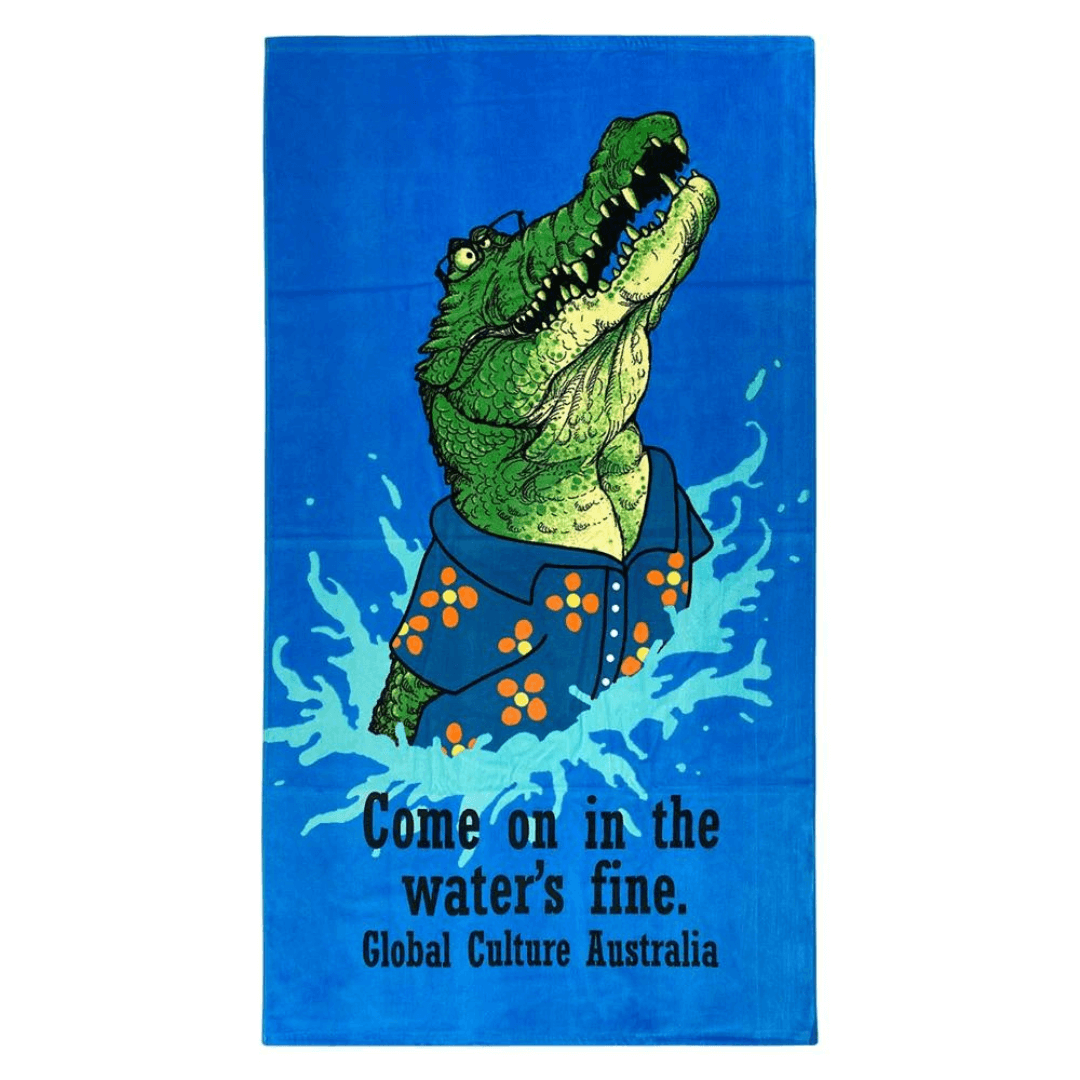 Stewarts Menswear Mullumbimby 100% cotton/velour beach towel with fun Australian theme print - Bright blue background with crocodile jumping out of water and slogan "Come on in the water's fine". Perfect gift for friends or relatives overseas or as a souvenir of your trip to Australia. Size 84cm x 148cm