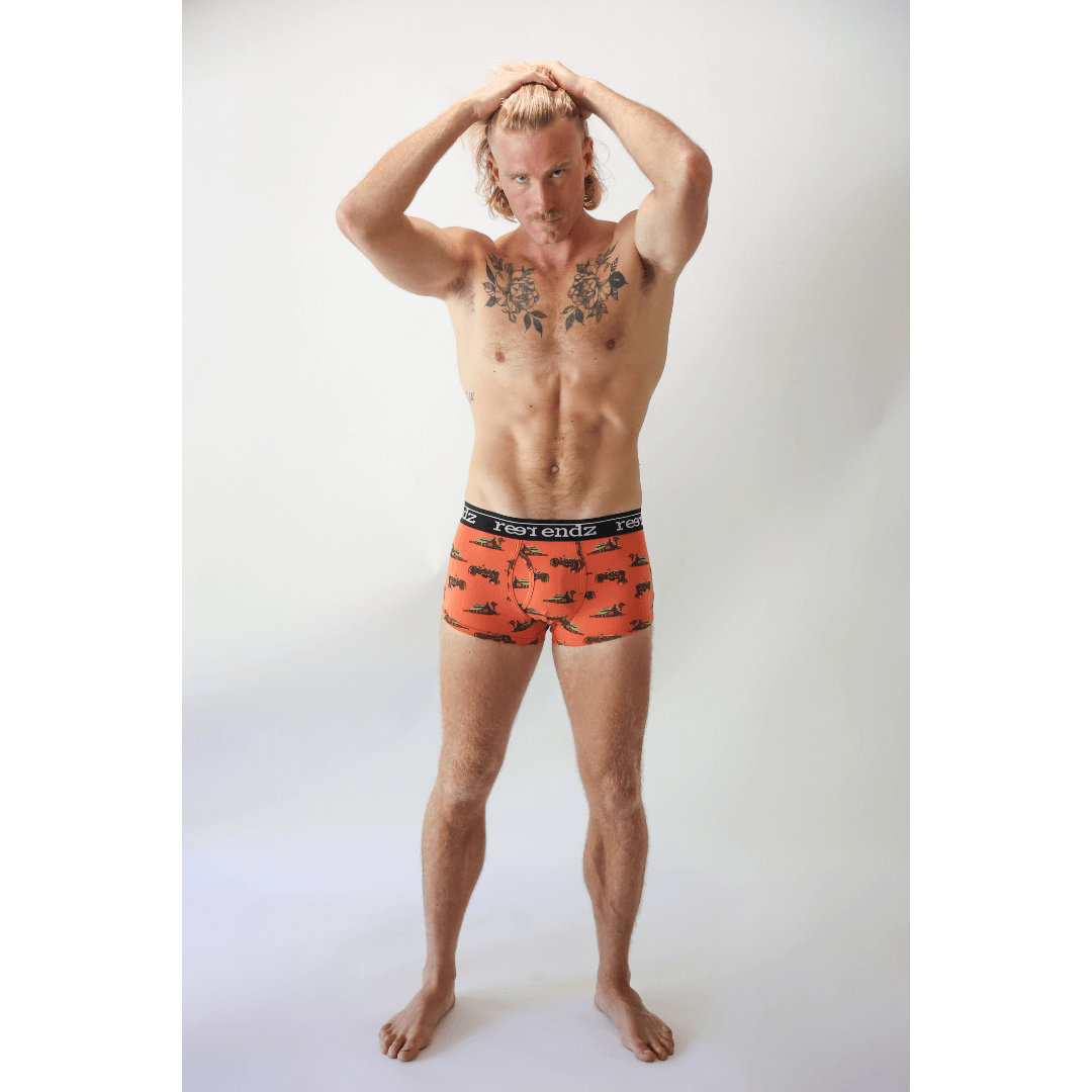 Stewarts Menswear Reer Endz Men's underwear. Made from Organic cotton. Image shows model wearing  Outback Feels print trunks. Orange trunks with farm machinery print. Front View.